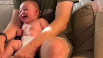 Baby-giggles-joyfully-as-playful-dogs-shower-him-with-attention.jpg